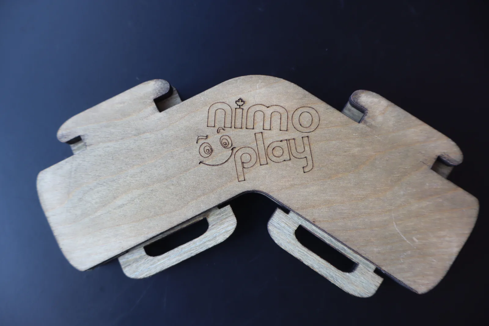 Close-up of a wooden NimoPlay connector piece with the NimoPlay logo