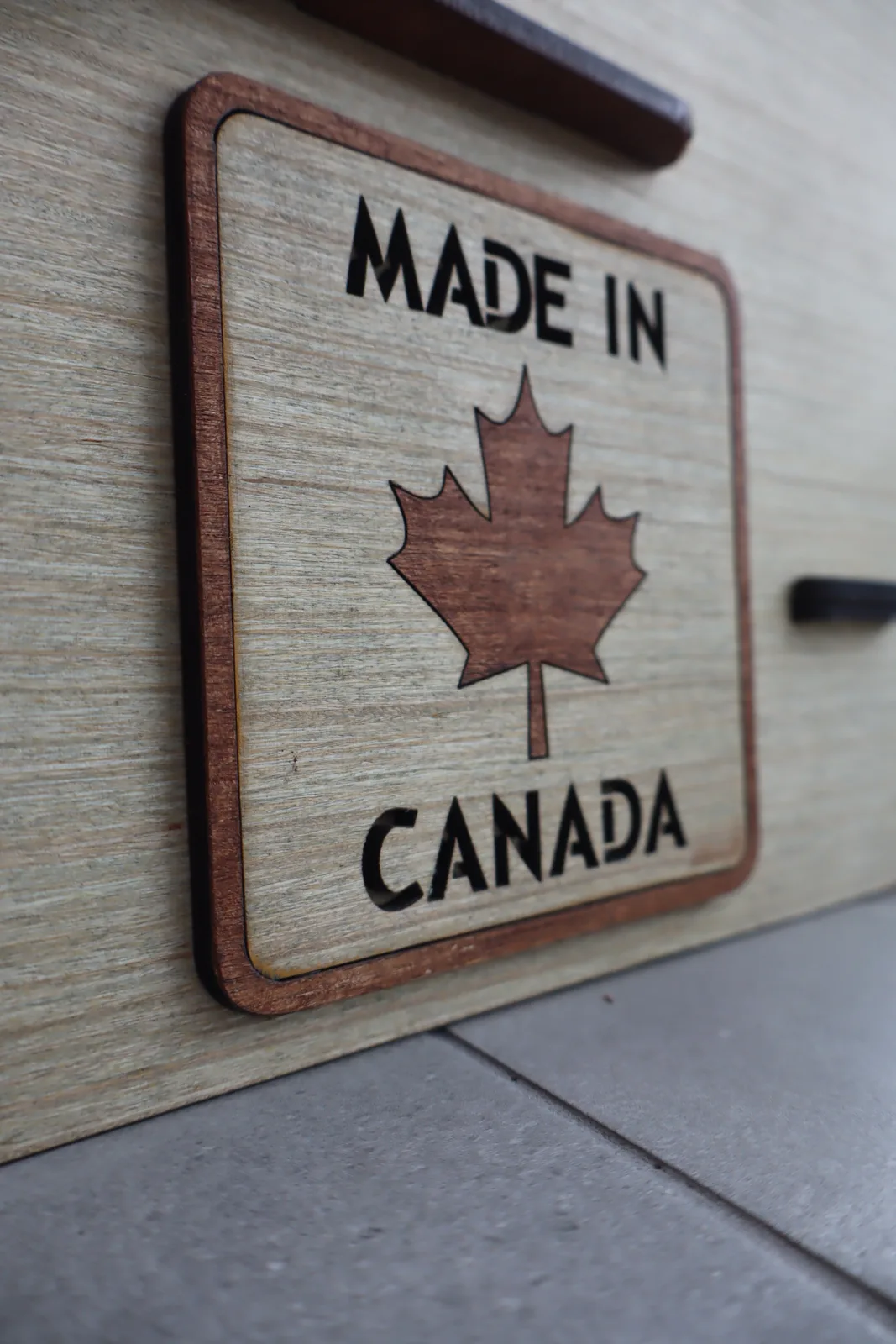 Made in Canada maple leaf badge on a wooden NimoPlay castle panel